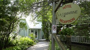 A sign for 'Hôtel La Camarine Rêception' with a no parking sign nearby. - Auberge La Camarine (Beaupre)