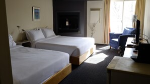 A hotel room with two beds, a desk with a computer, a TV, and a window with curtains. - Auberge La Camarine (Beaupre)