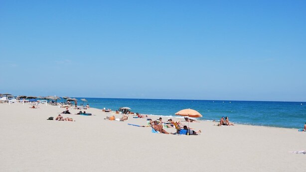 A beach with people sunbathing and swimming, umbrellas, and beach chairs. - Lagrange Vacances Les Jardins de Neptune (Saint-Cyprien)