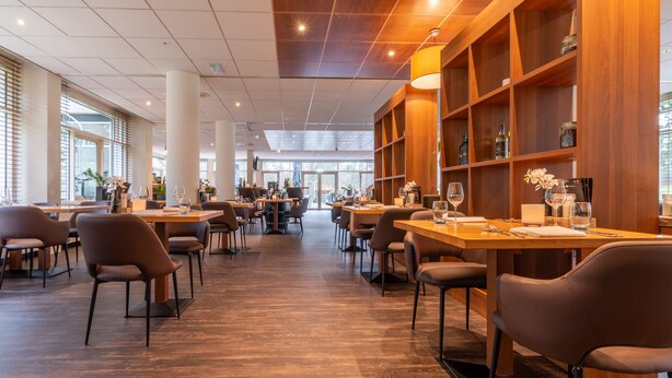 Tilava ravintola, jossa on korkeat katot, puupanelointi ja monipuoliset istumajärjestelyt.