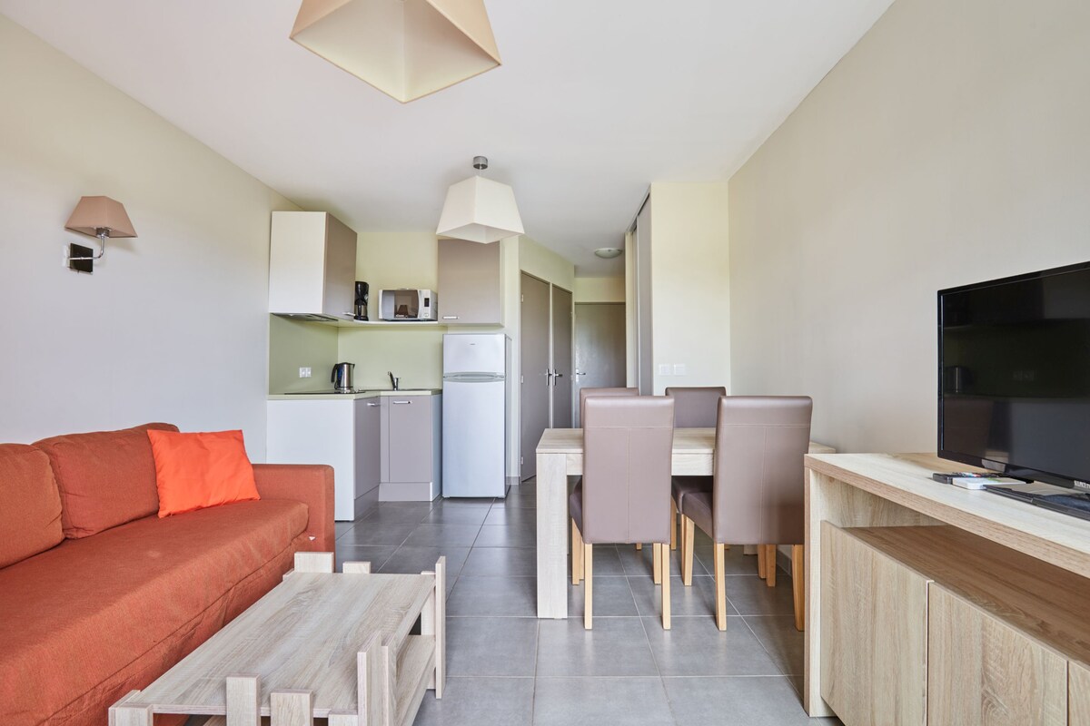 Un appartement moderne comprenant un espace de vie, un coin repas et une kitchenette.