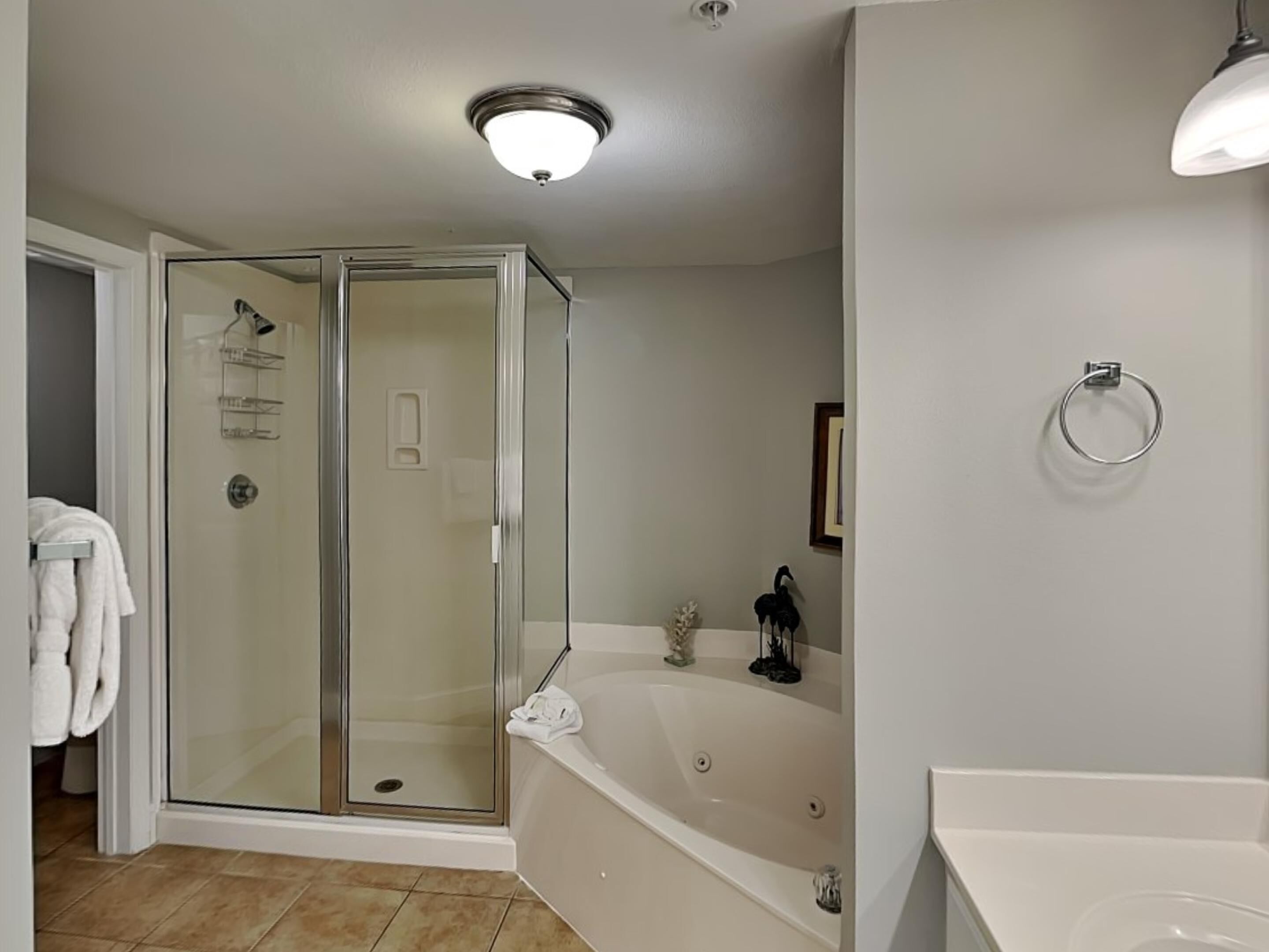 A modern bathroom with a glass-enclosed shower, a freestanding bathtub, and a white vanity.