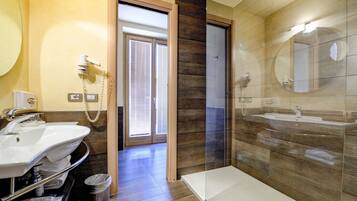 Un baño moderno con un espejo grande, dos lavamanos y una zona de ducha.