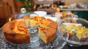 Una presentación de postres con varios pasteles y dulces sobre pedestales de vidrio.