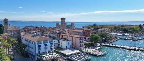A coastal town with historic buildings, a marina, and a tower.