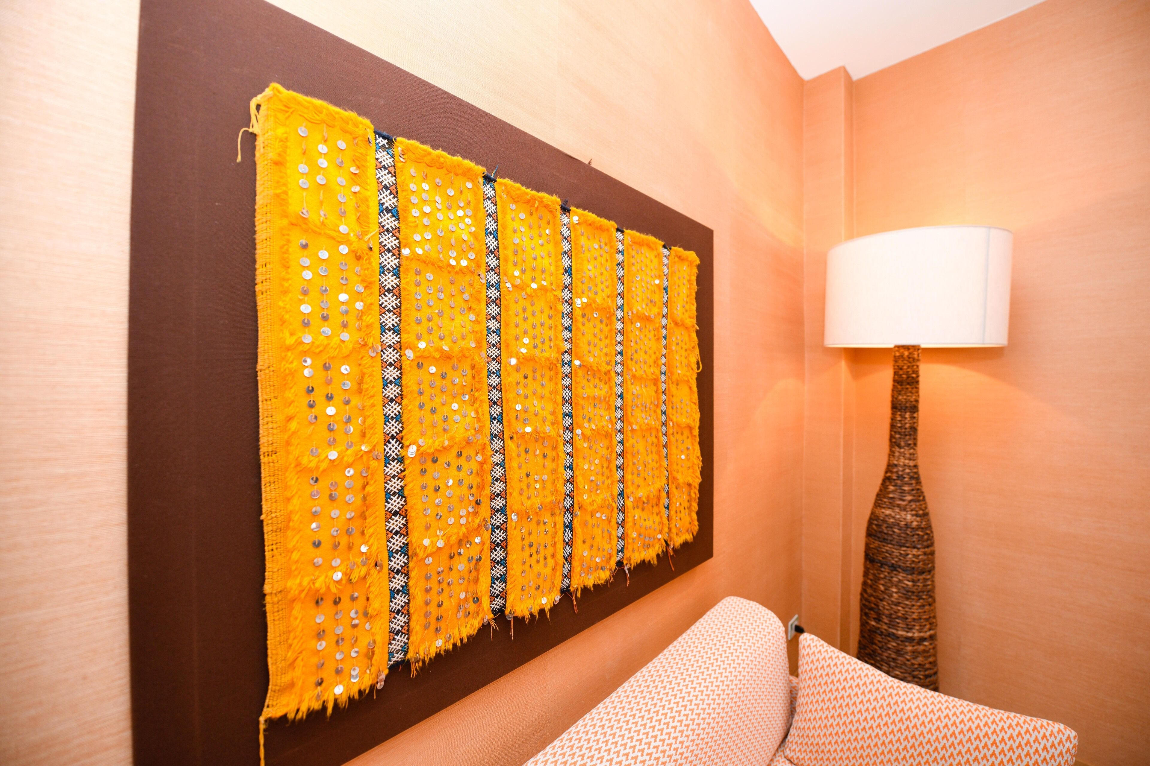 Une pièce avec un panneau décoratif mural à motifs, une lampe et un canapé.