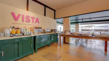 A breakfast area with a counter displaying various food items and a sign that reads "VISTA".