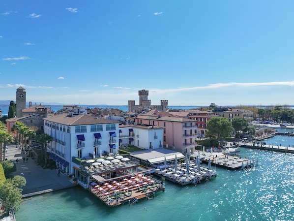 A coastal town with historic buildings, a marina, and outdoor dining areas.