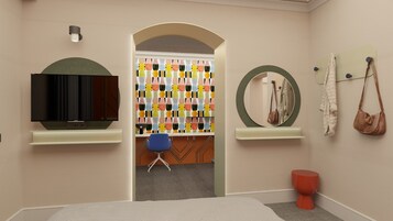 A hotel room with a television, a mirror, a chair, and a colorful wall decoration.