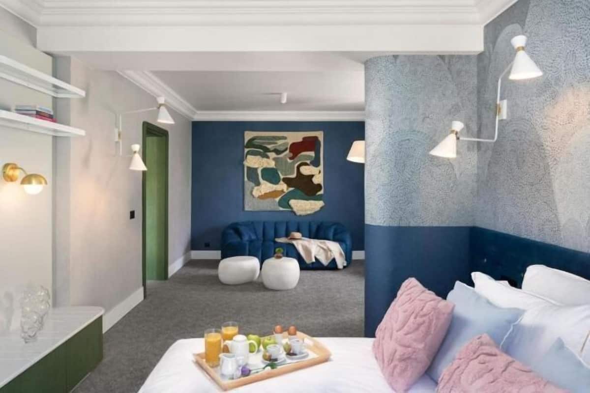 Un dormitorio moderno con cama, mesita de noche y bandeja para el desayuno.