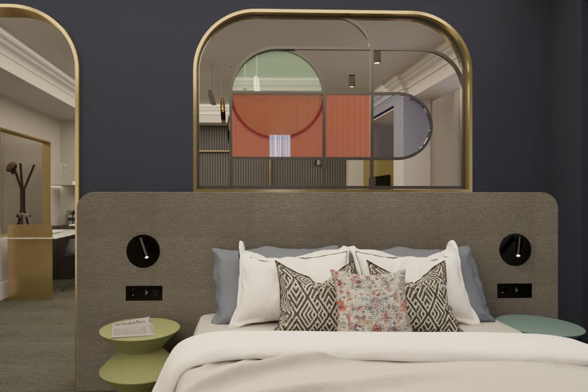 Un dormitorio moderno con un espejo grande, una cama con almohadones estampados, una mesita de noche pequeña y vistas a un pasillo.