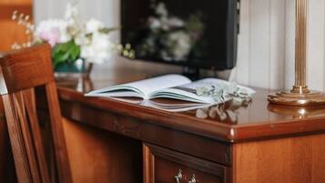 A wooden desk with an open book, a lamp, and a chair.