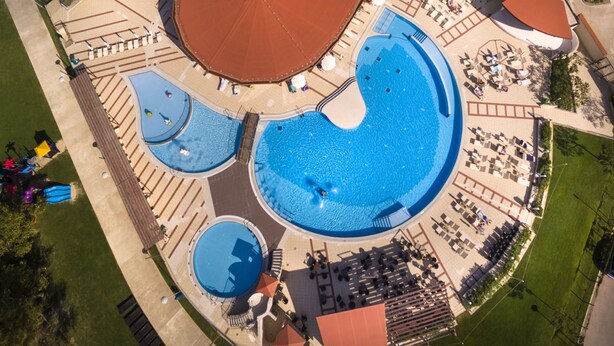 An aerial view of a resort with multiple swimming pools, sun loungers, and a covered area. - Sunny Baška Hotel by Valamar, ex Corinthia (Baska)