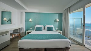 A hotel room with a bed, a desk, a chair, a nightstand, a mirror, and a balcony with a view of the sea. - BQ Apolo Hotel (Palma de Mallorca)