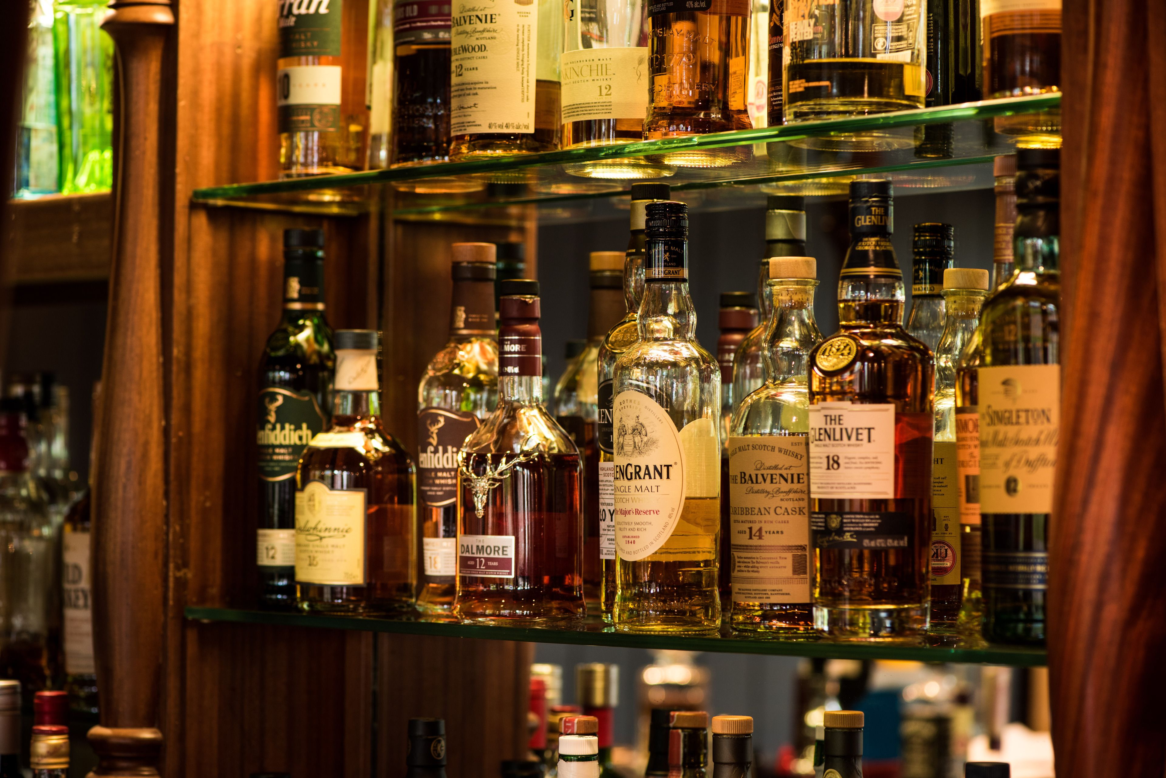 A bar with shelves stocked with various liquor bottles.