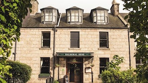 A stone building with a sign reading "Balmoral Arms." - Balmoral Arms (Ballater)