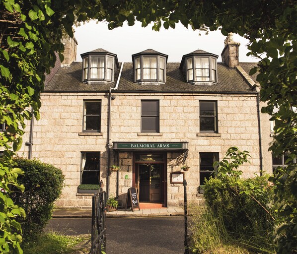 A stone building with a sign reading "Balmoral Arms."
