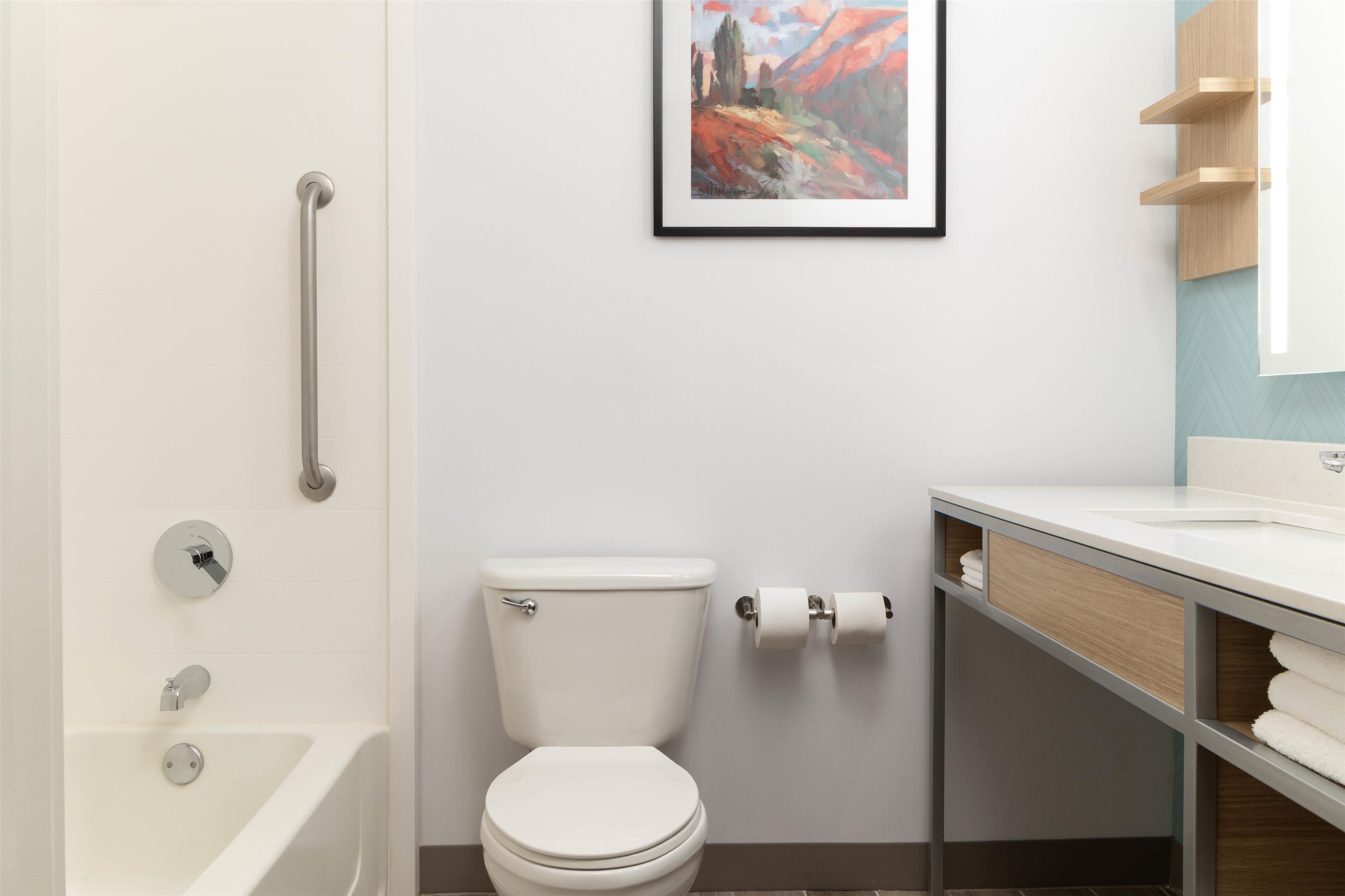 A modern bathroom with a bathtub, toilet, and sink.
