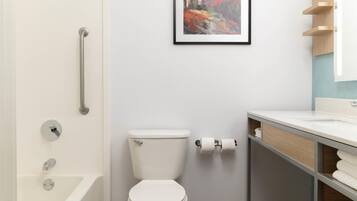A modern bathroom with a bathtub, toilet, and sink.