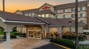 Un Hilton Garden Inn con una entrada acogedora, múltiples ventanas y un exterior bien cuidado.