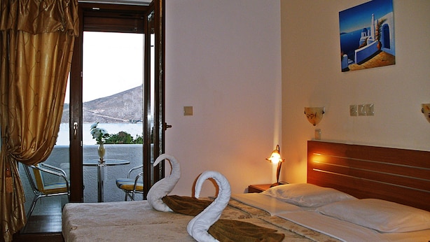 Habitación de hotel con cama, vista al mar y un cuadro en la pared.