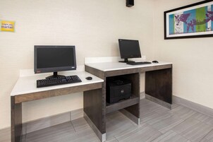 Un escritorio moderno de oficina con dos monitores, un teclado e impresora.
