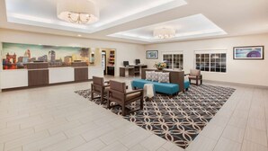 A spacious lobby with a reception desk, seating area, and artwork.