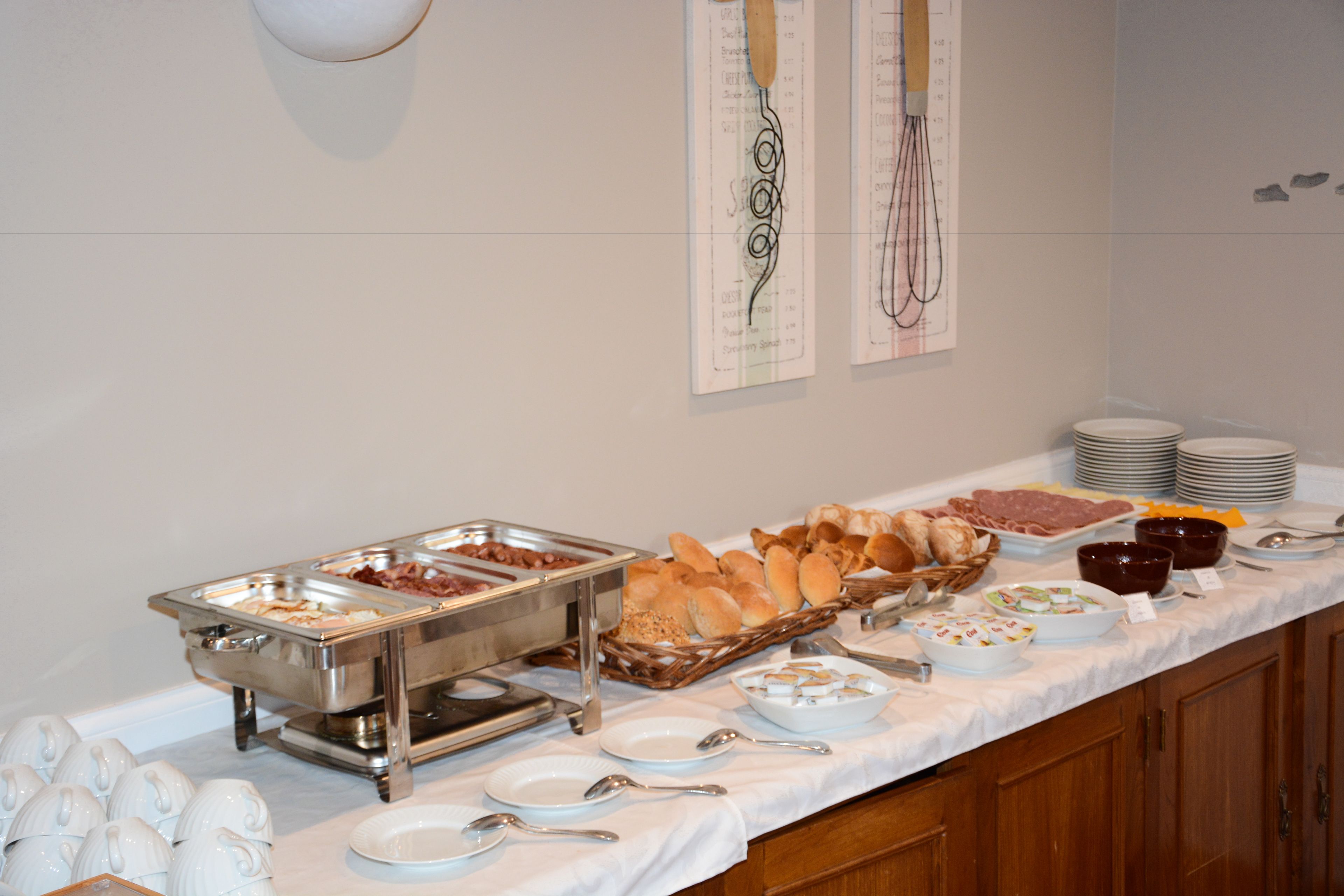 A buffet setup with various food items and utensils.