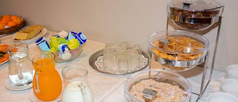 Una mesa de buffet con diferentes alimentos y bebidas.