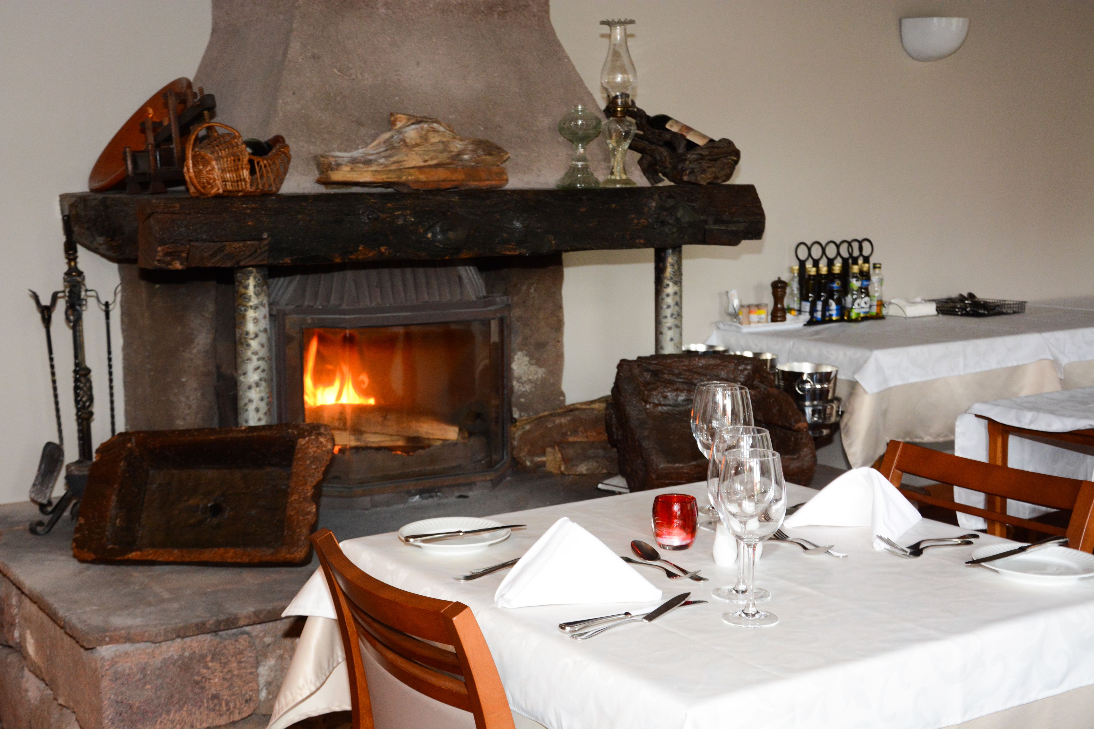 A dining area with a fireplace, wooden furniture, and a table set for a meal.