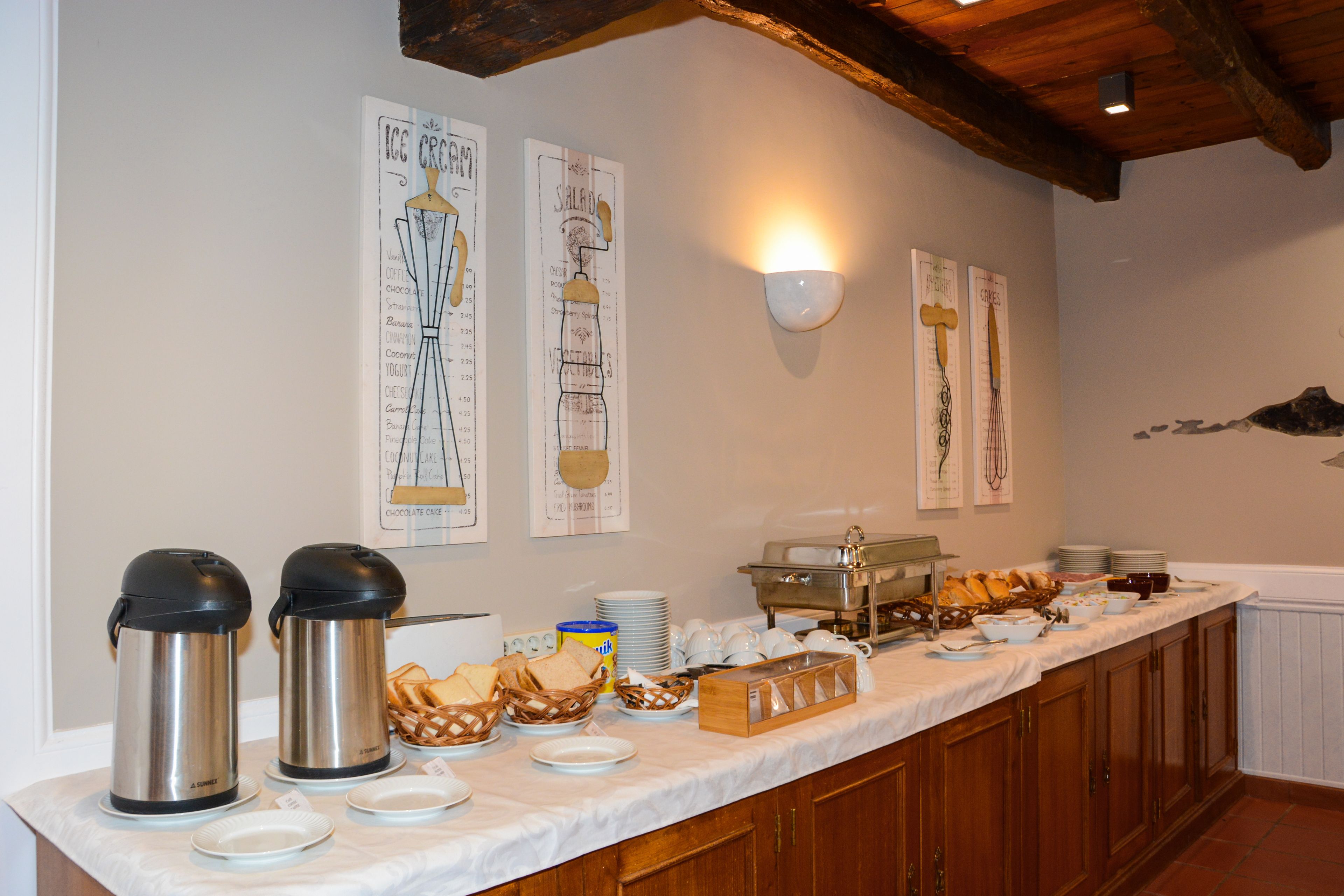 A buffet setup with various food items and serving utensils.