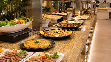 Un buffet con diversi piatti, tra cui carni, insalate e un piatto di pesce.
