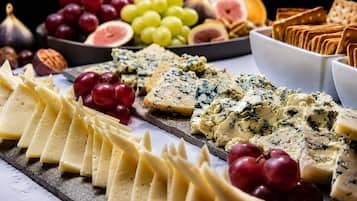 A variety of cheeses and fruits on a board.