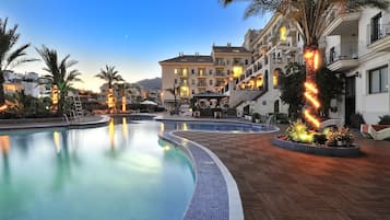 Een binnenzwembad, 2 buitenzwembaden en parasols bij het zwembad