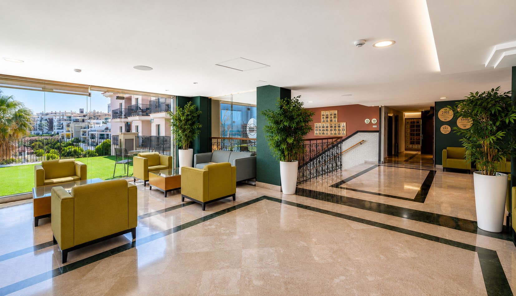 A hotel lobby with a view of the city, a staircase, and seating areas.