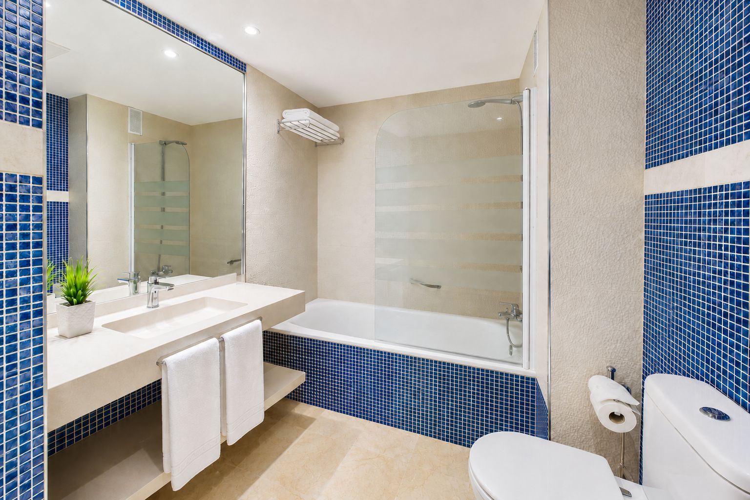 A modern bathroom with a bathtub, two sinks, a toilet, and a shower.