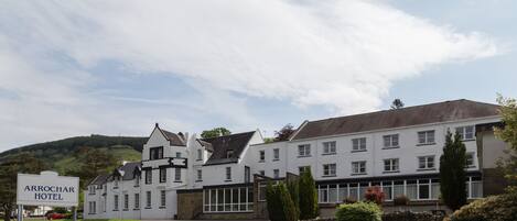 Un edificio grande y blanco con un letrero que dice "Arrochar Hotel".
