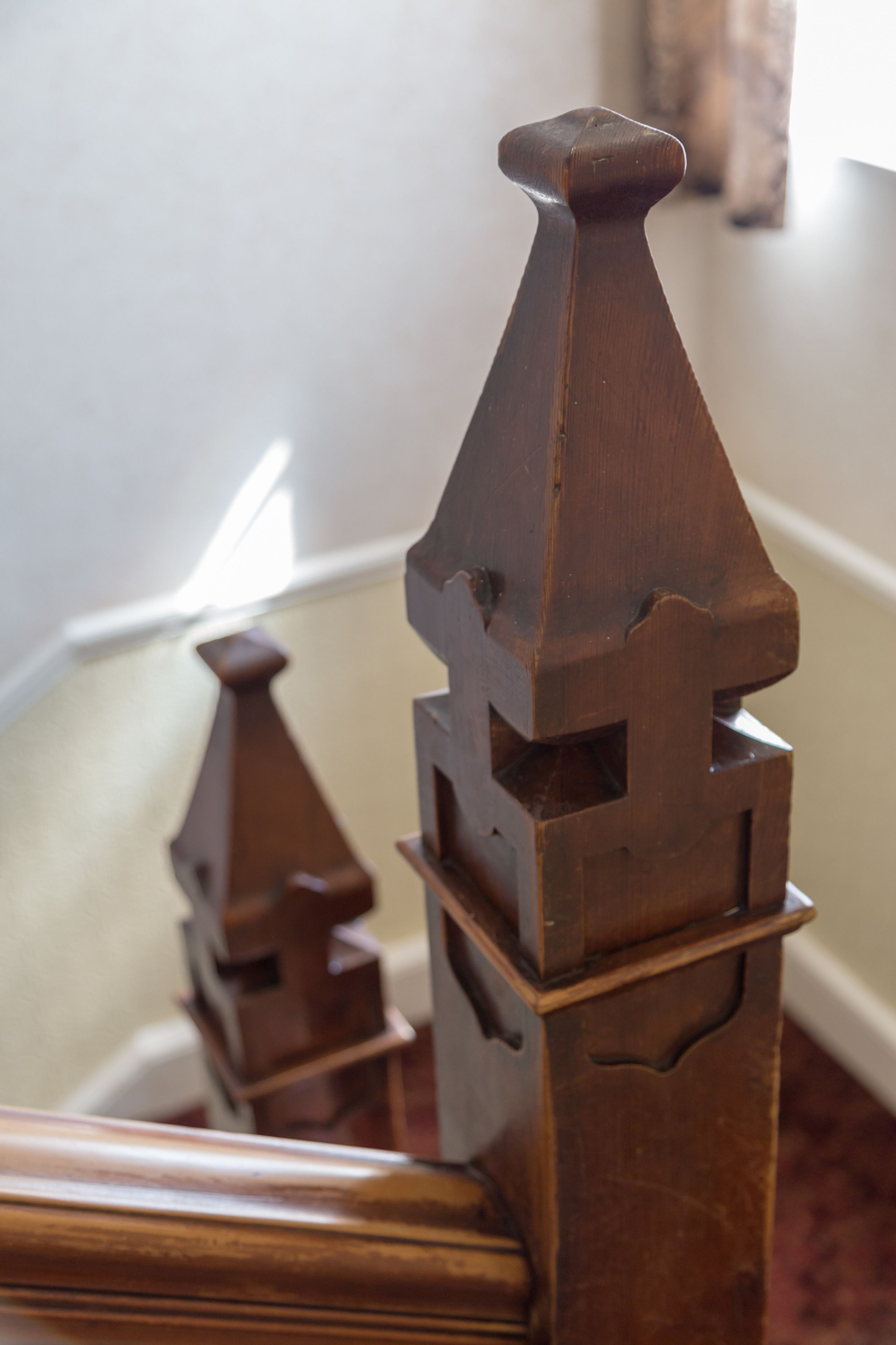 A close-up of a wooden chair with a unique, geometric design.
