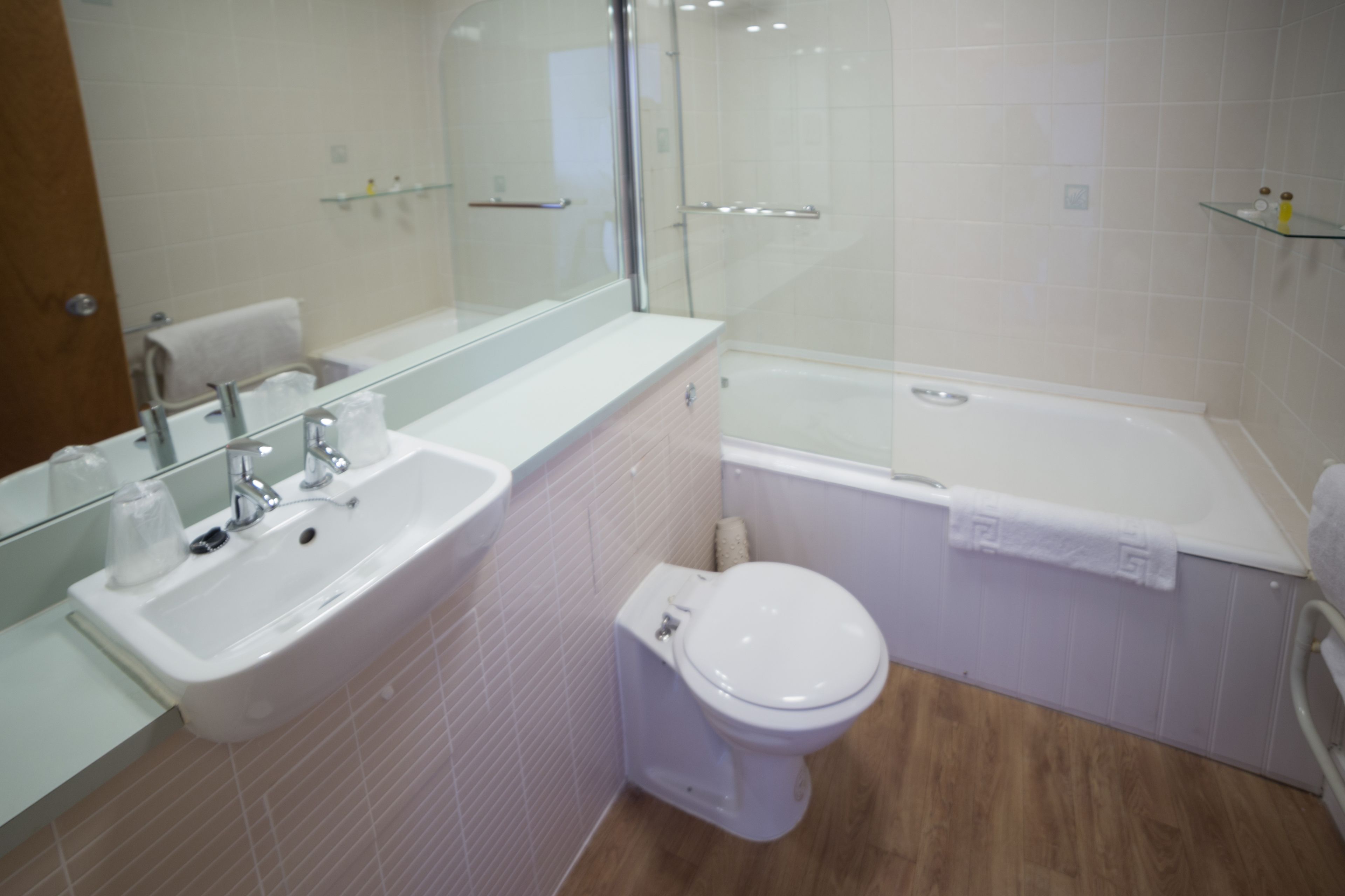 A modern bathroom with a sink, toilet, and bathtub.