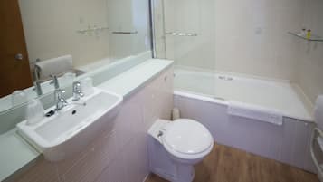 A modern bathroom with a sink, toilet, and bathtub.
