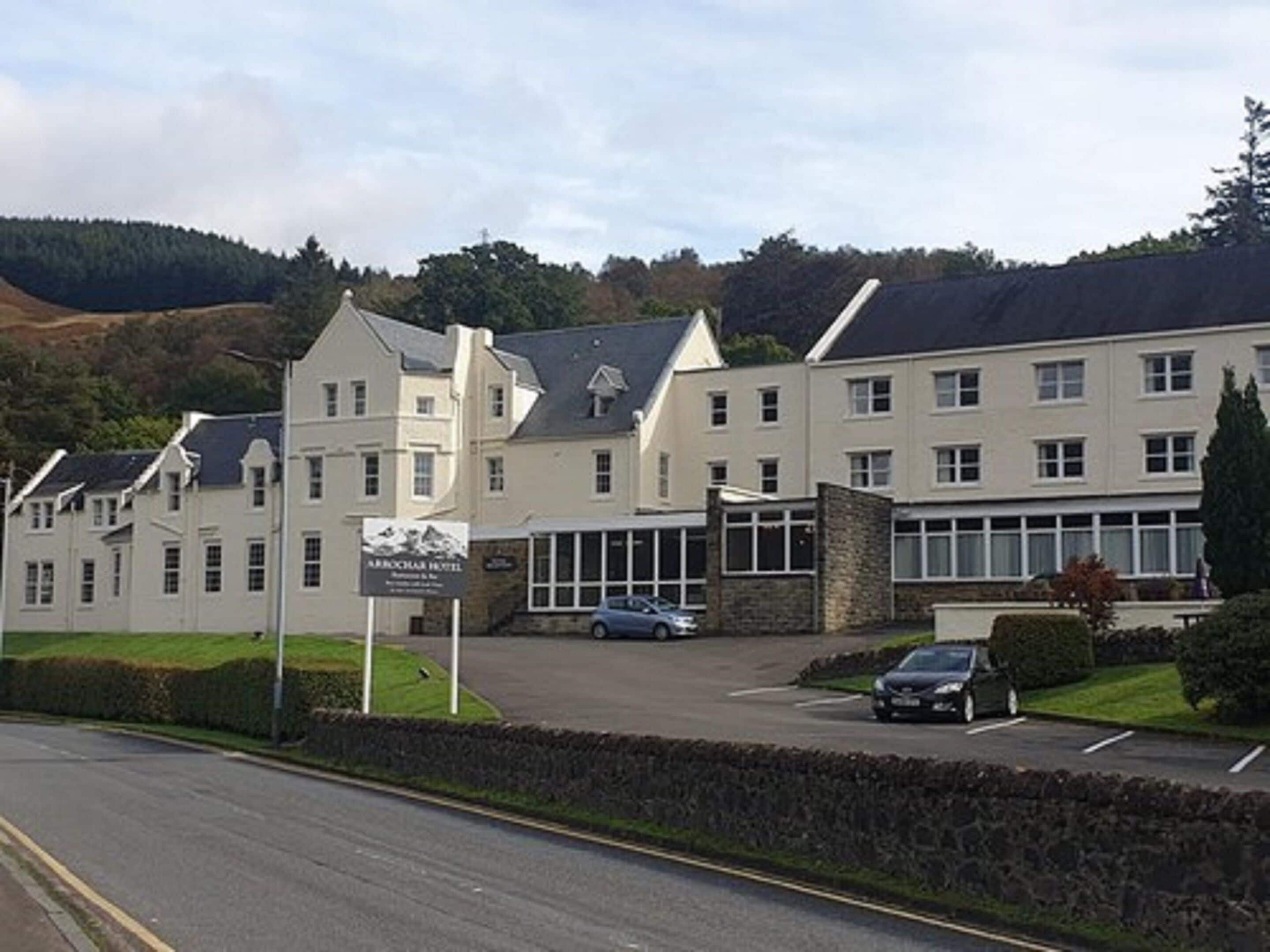 A hotel with a traditional architectural style, featuring multiple windows and a central entrance.