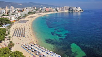 Una spiaggia nelle vicinanze, sabbia bianca, lettini da mare, ombrelloni