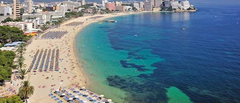 Nära stranden, vit sandstrand, solstolar och parasoller