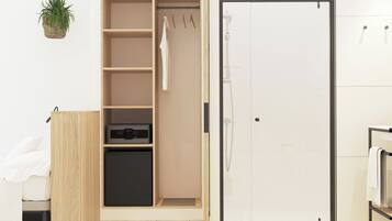 A walk-in closet with shelves, a hanging rack, and a small appliance.