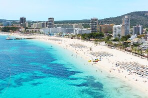 Nära stranden, vit sandstrand, solstolar och parasoller