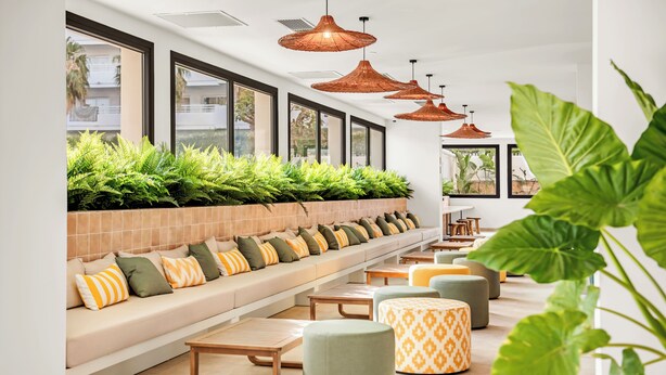 A modern lounge area with a long bench, cushioned seating, pendant lighting, and potted plants. - Tangerine by Honne Hotels - Adults Only ¨New Opennig¨ (Calvia)