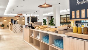 A modern cafe interior with a counter displaying pastries and beverages, a wall with a menu, and a clean, organized layout. - Tangerine by Honne Hotels - Adults Only ¨New Opennig¨ (Calvia)