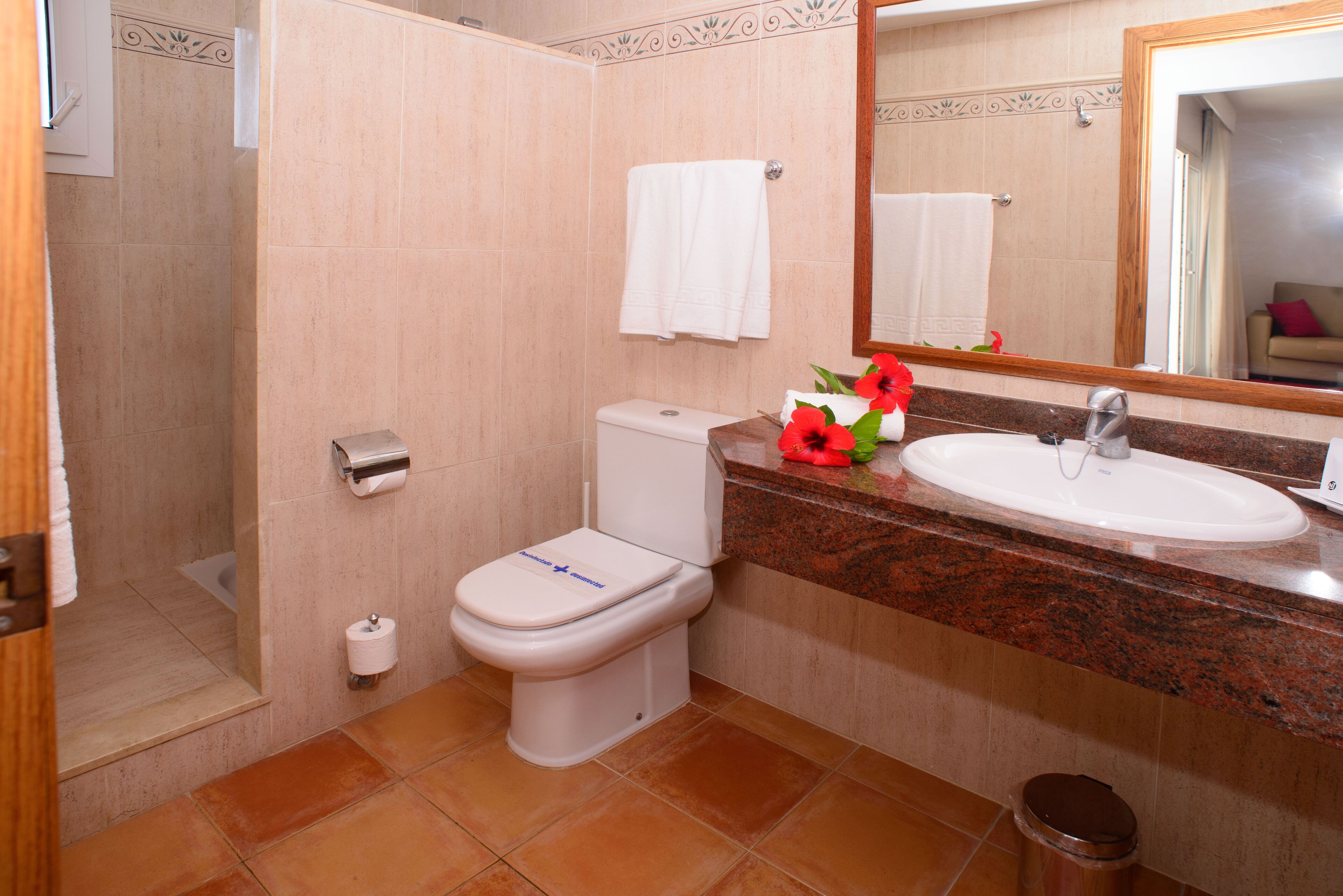 A bathroom with a toilet, sink, and shower.