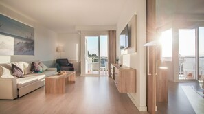 Ein modernes Wohnzimmer mit einer Couch, einem Couchtisch und einem an der Wand befestigten Fernseher.