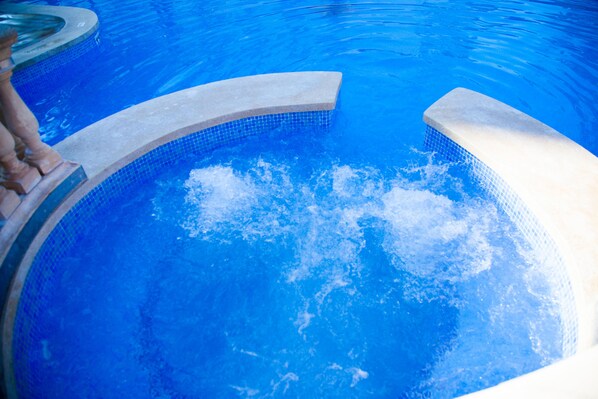 Ein Schwimmbecken mit klarem, blauem Wasser und einer Steinkante.